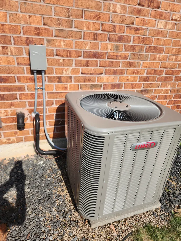 Lennox central air conditioner installed beside a brick home