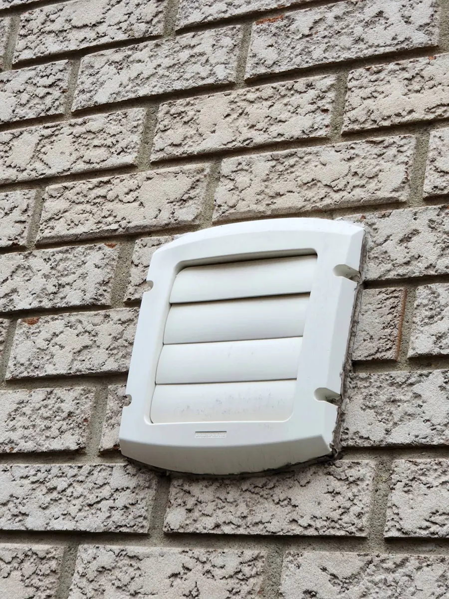 Exterior dryer vent installed through brick