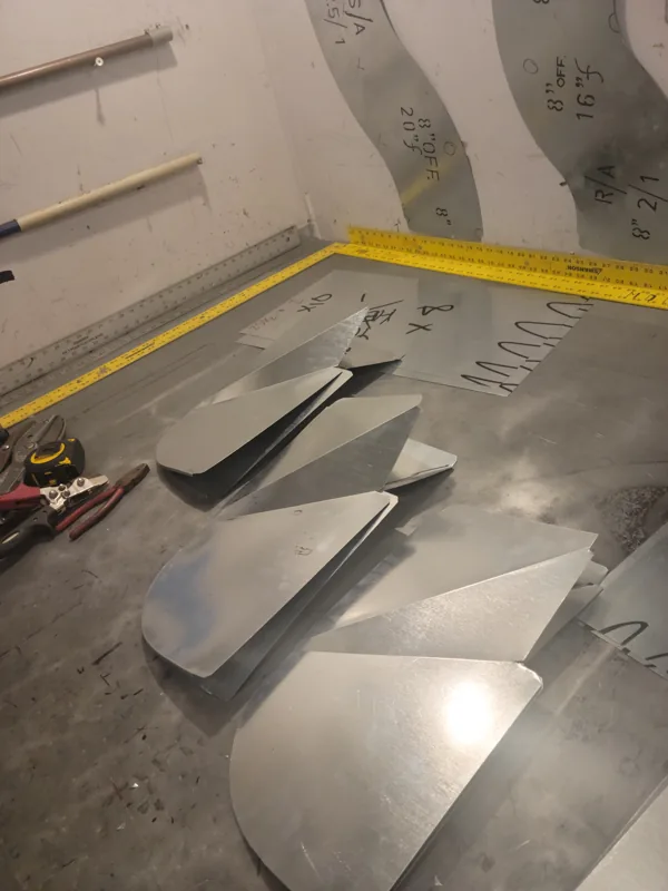 Galvanized fitting pieces cut and laid out on the bench